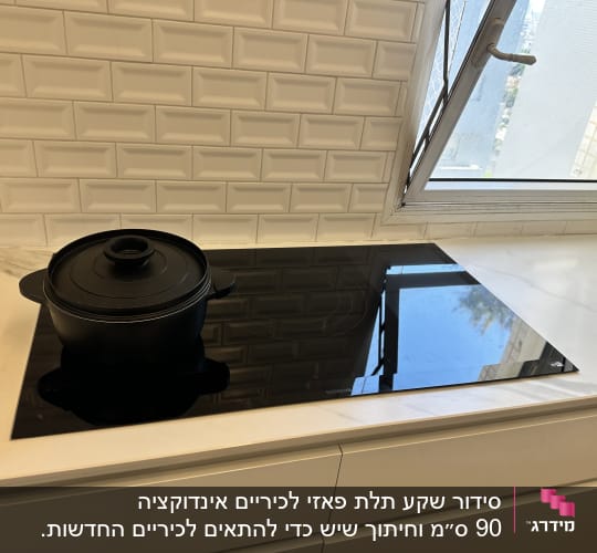 כיריים חשמליות עם סיר שחור במטבח